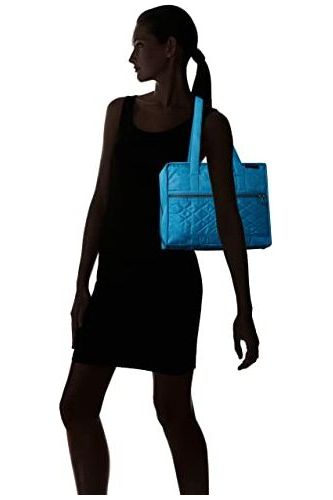 a woman in a blue dress is holding a purse